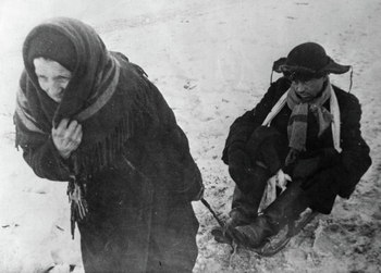 В дни блокады Ленинграда (8 сентября 1941 года - 27 января 1944 года). Женщина везет ослабевшего от голода мужа на санках. Великая Отечественная война...