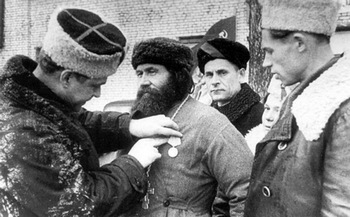 Командир 5-й Ленинградской партизанской бригады, Герой Советского Союза Камрицкий К.Д. прикрепляет медаль «Партизану Отечественной войны II степени» священнику церкви Порховского района Пузанову Ф.А