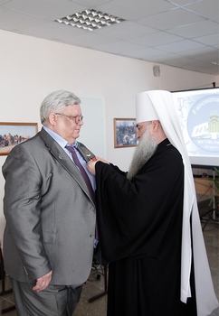 Митрополит Лонгин вручает медаль Александру Ватолину