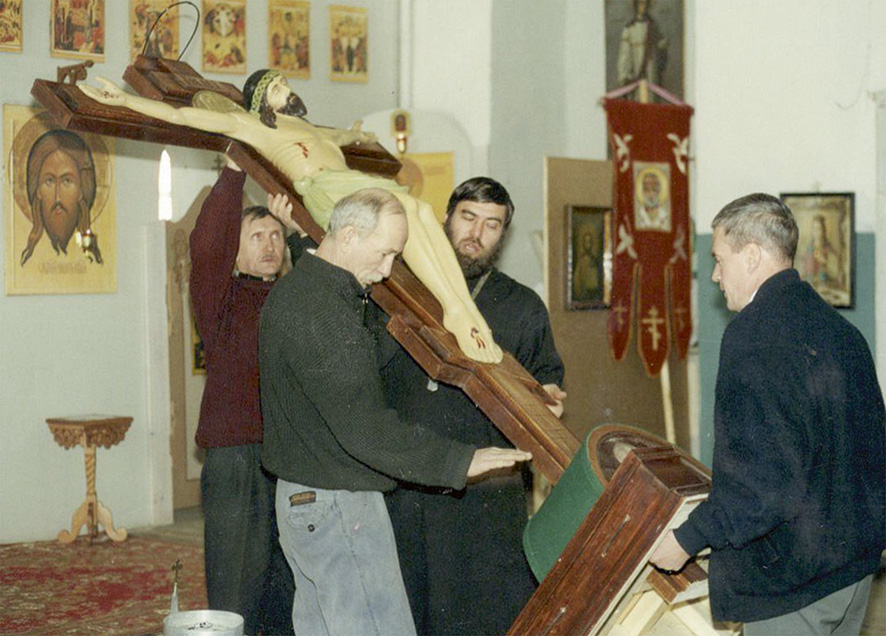 Скульптор Владимир Чибисов (на переднем плане) и отец Сергий Захарья устанавливают Голгофу на положенное место в храме